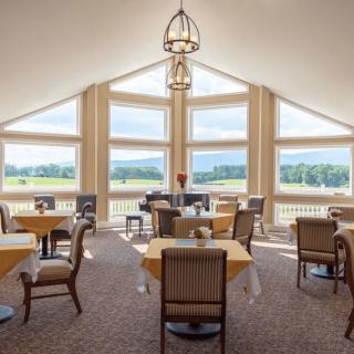 A modern dining area with large windows offering a scenic view.