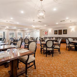 An elegant restaurant dining room with neatly arranged tables and chairs.