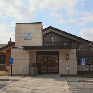 A modern commercial building with large windows and accessible entrance.