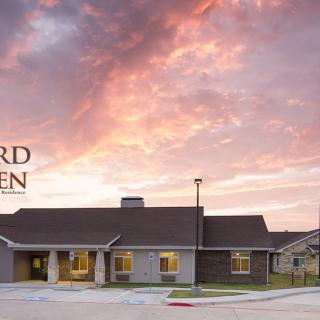 A residential building set against a vibrant sunset sky with scattered clouds.