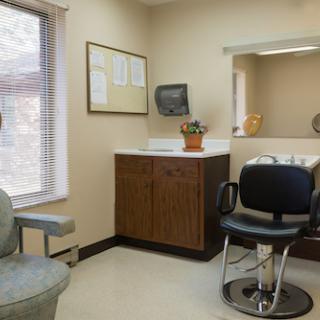 A view of a dentist's office featuring a waiting area and examination chair.