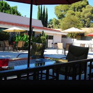 A sunny outdoor patio with tables, chairs, and umbrellas perfect for relaxing.