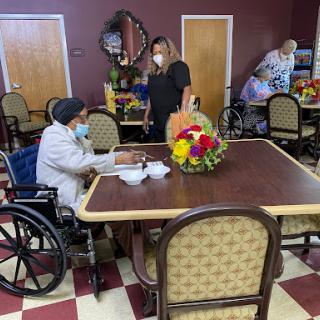 Residents and staff engaging in a social moment in a care facility's dining area.