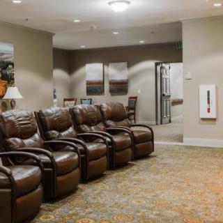 A cozy waiting room with leather recliners and carpeted flooring.