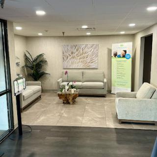 A modern and inviting lobby area featuring comfortable seating, decorative art, and greenery.
