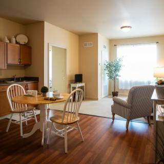 A cozy, naturally lit living space with a small dining area and kitchen.