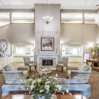 A luxurious living room featuring a central fireplace, elegant furnishings, and a chandelier.