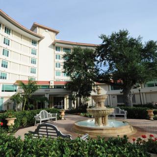 A hotel exterior with a central fountain and landscaped surroundings.