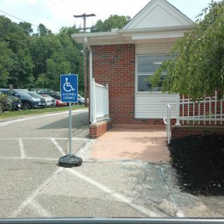 A designated handicapped parking area with an accessible entrance next to a building.
