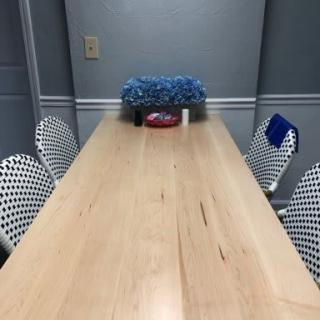 A long wooden dining table with patterned chairs and a decorative centerpiece in a modern dining room.