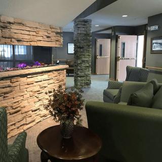 A cozy lobby area with comfortable seating and a decorative stone wall.