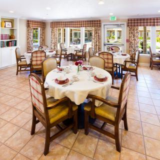 A bright and inviting dining area with elegantly set tables and comfortable chairs.