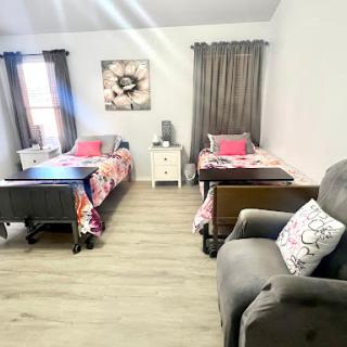 A cozy and inviting bedroom setup with two beds, a comfortable sofa, and stylish decor.
