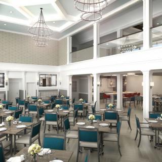 A modern dining area with elegant chandeliers and neatly arranged tables and chairs.
