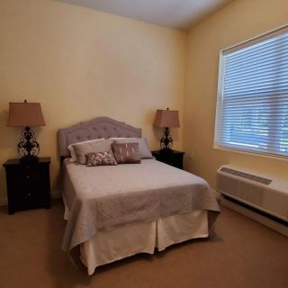 A cozy bedroom with a neatly made bed and side lamps.