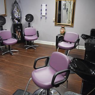 An interior view of a hair salon with styling chairs and mirrors.