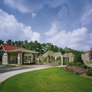 A welcoming entrance to a beautifully designed residential community set against a clear blue sky.