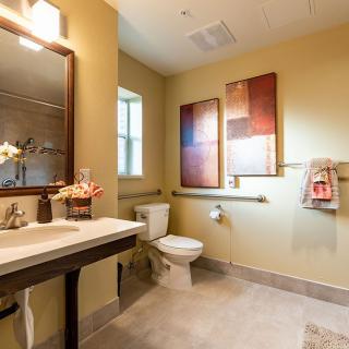 A well-lit bathroom interior featuring modern decor and artwork.