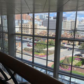 A view of the city skyline through large windows, showcasing urban architecture and bustling streets.