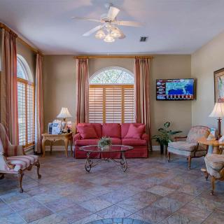 A cozy living room with a red sofa, elegant chairs, and a mounted television.