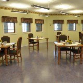 An empty dining room with several tables and chairs arranged neatly.