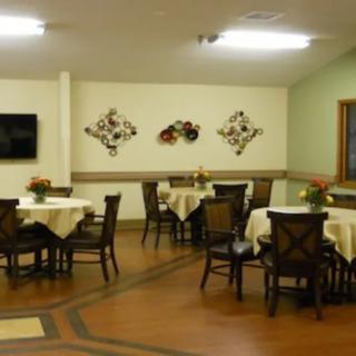 A cozy dining room with several tables and chairs, adorned with wall decorations.