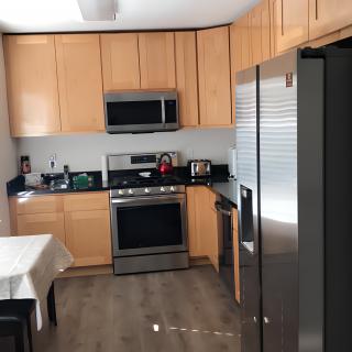 A modern kitchen with wooden cabinets and stainless steel appliances.