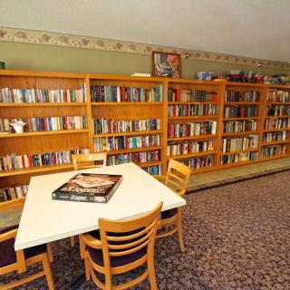A cozy library corner with bookshelves and a reading table.
