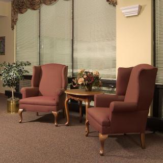 A cozy living room setup featuring two armchairs, a small table, and decorative elements.