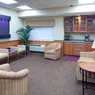 A cozy waiting room with seating, wooden cabinets, and ambient lighting.