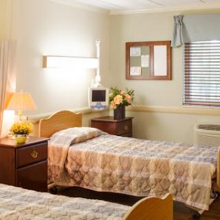 A cozy hospital room with two beds, soft lighting, and a warm atmosphere.