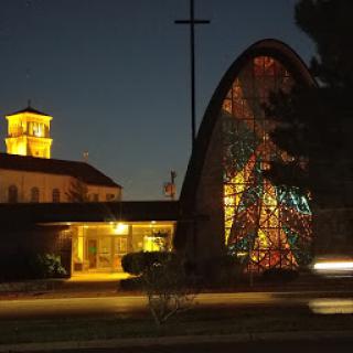 A beautifully illuminated church at night, featuring unique architectural elements and vibrant stained glass.