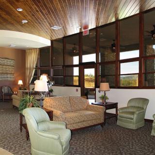 A cozy lobby with comfortable seating, large windows, and warm lighting.