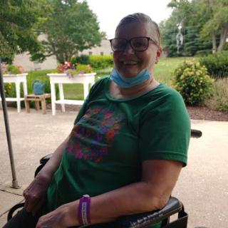 A cheerful individual in a wheelchair enjoying time outdoors.
