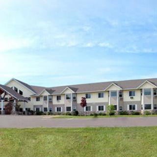 A two-story hotel building with a well-maintained exterior and a clear blue sky.