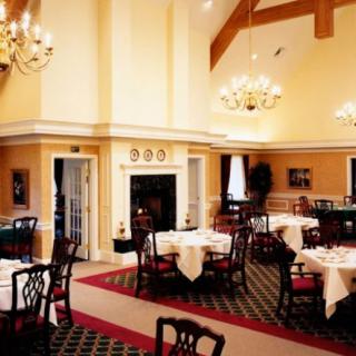 An elegant dining room with chandeliers and neatly arranged tables and chairs.