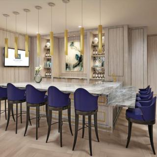 A modern bar area with blue chairs, elegant lighting, and contemporary artwork.