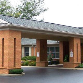 A welcoming entrance to a brick building with well-maintained landscaping.