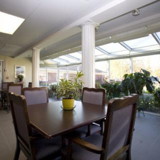 A bright and inviting dining area with a large wooden table, comfortable chairs, and plenty of natural light.