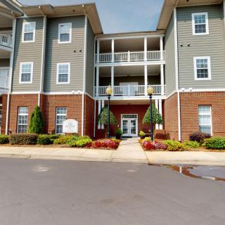 A modern apartment building with a well-maintained entrance and landscaping.
