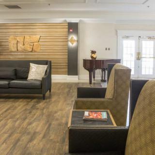 A modern lobby with comfortable seating and a piano.