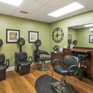 A well-equipped hair salon with chairs, mirrors, and hair dryers.