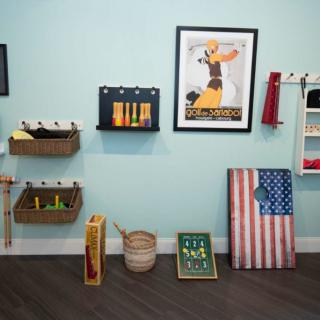 A curated art display features a vintage-styled poster, American flag artwork, and various decorative items on shelves.