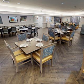 A modern restaurant dining area with neatly arranged tables and chairs, featuring elegant interior design.