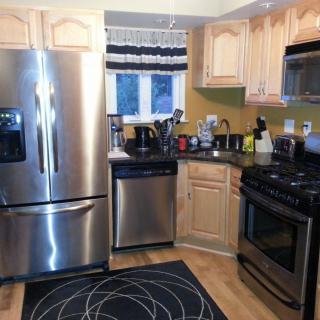 A modern kitchen with stainless steel appliances and wooden cabinets.