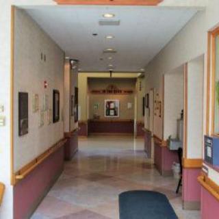 A well-lit hallway with artwork and doors leading to various rooms.