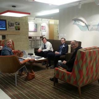 A group of people having a meeting in an office lobby area.