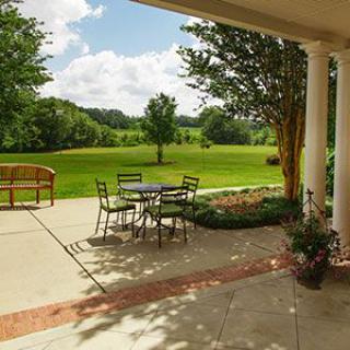 A serene patio with outdoor seating overlooking a lush garden and open landscape.
