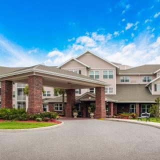 A large residential building with an inviting entrance under a clear blue sky.