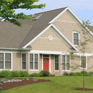 A suburban house with a well-maintained lawn and landscaping.